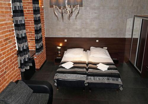 a bedroom with two beds in a brick wall at Aparthotel Łódź 55 Piotrkowska in Łódź
