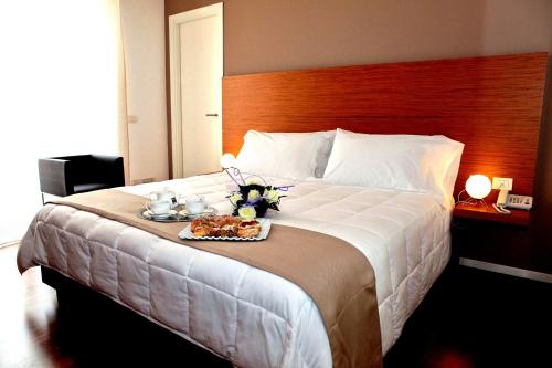 una camera d'albergo con un letto e un vassoio di cibo sopra di Hotel La Dimora di Piazza Carmine a Ragusa