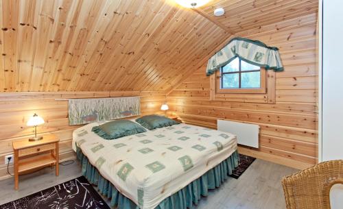 1 dormitorio con 1 cama en una cabaña de madera en Holiday Club Ähtäri Cottages, en Ähtäri