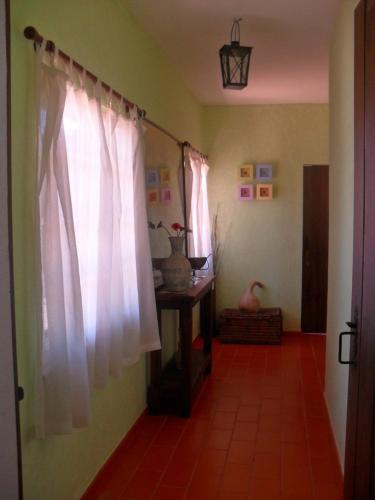 a hallway with a white curtain and a room with a table at Monte da Pereira in São Cristóvão