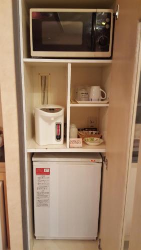 a microwave oven sitting on top of a refrigerator at Hotel Elegance (Love Hotel) in Karatsu