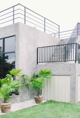 a house with palm trees in front of it at La moon in Ban Pa Tung (7)