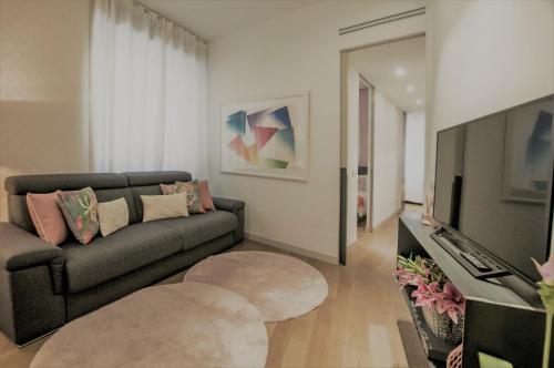 a living room filled with furniture and a tv at Madeleine apartments in Brera in Milan