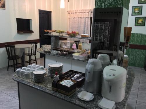 a kitchen with a counter with plates and food at Hotel Meyer in Francisco Beltrão