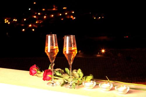 two glasses of champagne on a table with flowers at Hotel La Dimora di Piazza Carmine in Ragusa