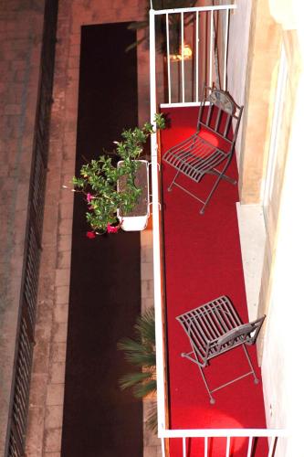 a balcony with a chair and potted plants on it at Hotel La Dimora di Piazza Carmine in Ragusa