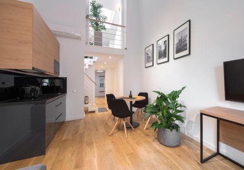 a kitchen and dining room with a table and chairs at Aparthotel BC 29 Residence in Kraków