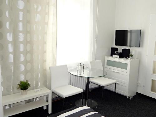 a room with a table and chairs and a tv at Apartments Ostrava Vítkovice in Ostrava