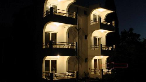 a lit up building with balconies at night at Studios Milošev in Bar