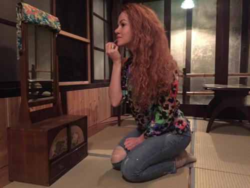 a woman sitting on the floor next to a mirror at YUMEJI Vintage Villa in Kyoto
