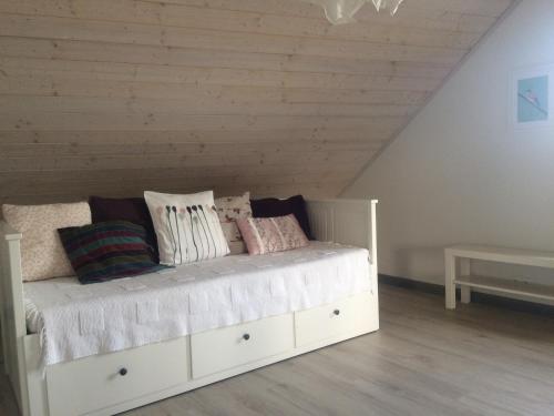 a white bed with pillows on it in a room at Chamedafne w Puszczy Kampinoskiej in Brochów