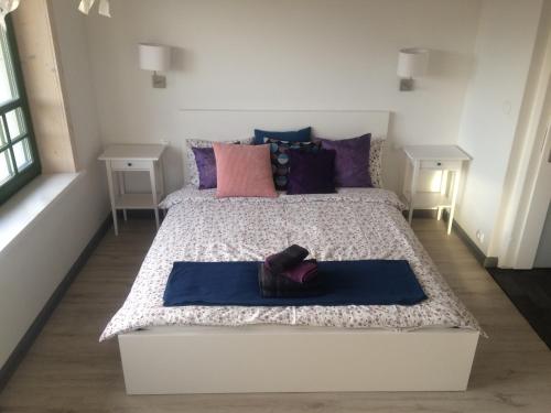 a bedroom with a large bed with purple pillows at Chamedafne w Puszczy Kampinoskiej in Brochów