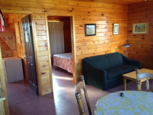 Habitación con 1 cama y 1 silla en una cabaña en Sea'scape Cottages en Bayfield