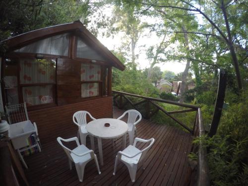 a wooden deck with a table and chairs on it at Cabañas Manamar in Villa Gesell