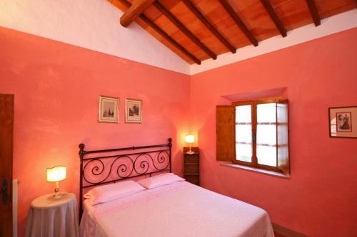 a red bedroom with a bed and a window at Villa Castiglione by PosarelliVillas in Contignano