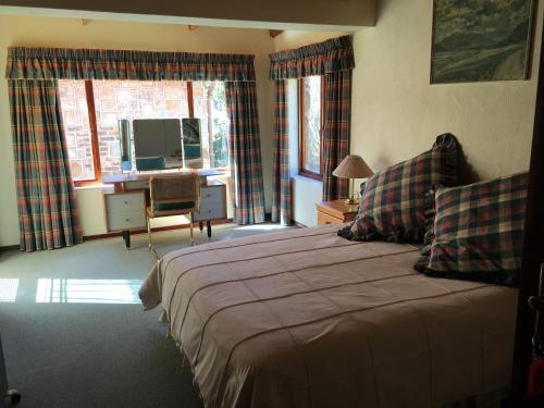 a bedroom with a bed and a television in it at Marigold's 37 Critchley Common in Dullstroom