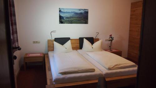 a bedroom with a bed with two pillows on it at Pension Wagnerhof in Oberaudorf
