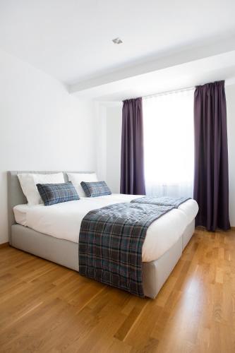 a bedroom with a large bed with purple curtains at Brzeće Center Apartments in Kopaonik