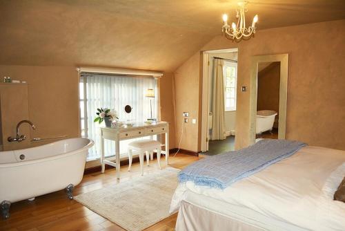 a bedroom with a large bed and a bath tub at Spring Water Barn in Helston