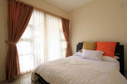a bedroom with a bed and a large window at Springhill Villa Syariah in Bandung