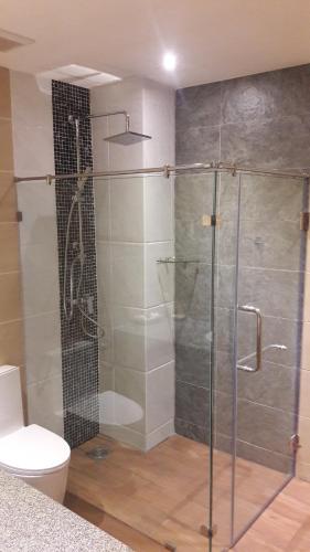 Un baño con ducha de cristal con inodoro. en Tolmaj Family Apartment, en Ao Nang Beach