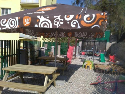 a patio with a picnic table and an umbrella at Penzion Pomodoro in Vrbno pod Pradědem