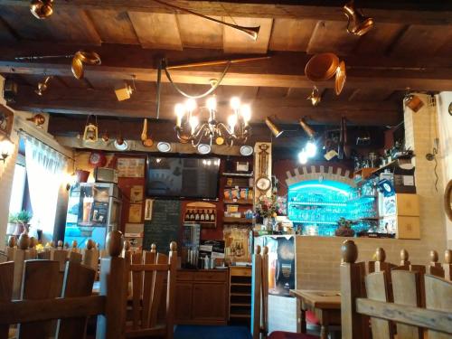 a restaurant with a bar with wooden walls and chairs at Penzion Pomodoro in Vrbno pod Pradědem