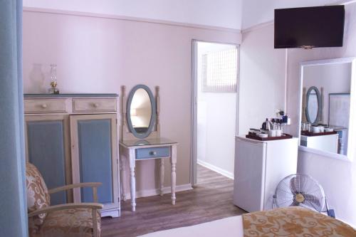 a room with a mirror and a dresser with a table at Lockerbie Lodge in Vryburg