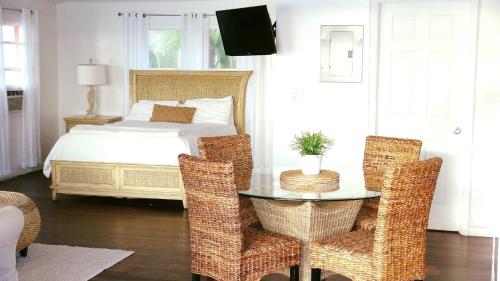 a bedroom with a bed and a table and chairs at The Sands Hotel in Cockburn Town