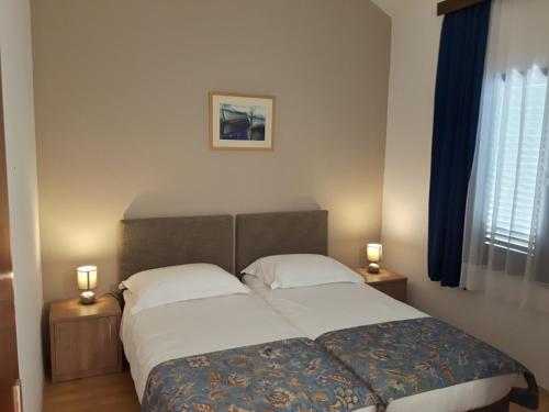 a bedroom with a large bed with two lamps on tables at Amadria Park Camping Trogir - Apartments in Seget Vranjica