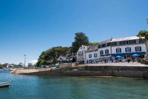 a group of buildings next to a body of water at Hotel Du Bac in Combrit
