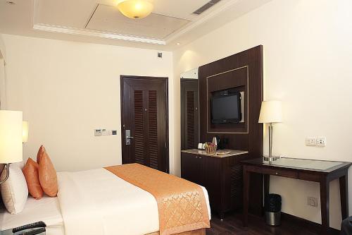 a hotel room with a bed and a television at Inde Hotel Signature Tower in Gurgaon