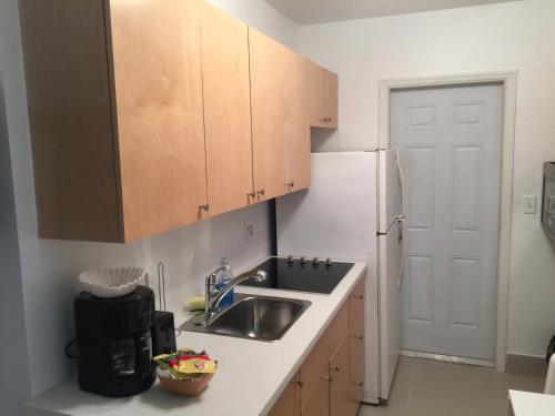a small kitchen with a sink and a refrigerator at Pelican By The Sea in Pompano Beach