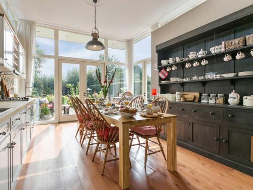 cocina con mesa de madera y sillas en B&B Het Pronkbed en Oirschot