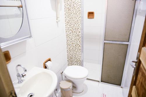 a small bathroom with a toilet and a sink at Hotel Aliança in Vila Velha