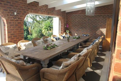 a dining room with a long table and chairs at Le Residence de Josephine in Kloof