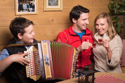 a man and woman playing an accordion with a boy at Biobauernhof Tonimörtl in Mariapfarr