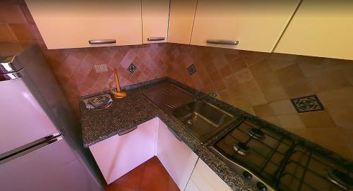uma vista superior de uma cozinha com um lavatório em Villaggio Piscina Rei em Monte Nai