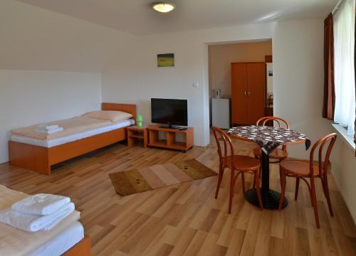 a room with a table and a bedroom with a bed at Apartmany Broma in Liptovský Mikuláš
