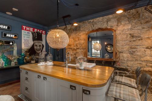 a bar in a room with a stone wall at The Baxter Hostel in Edinburgh