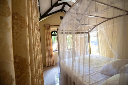 a bedroom with a canopy bed with a window at Dream Villa in Mirissa