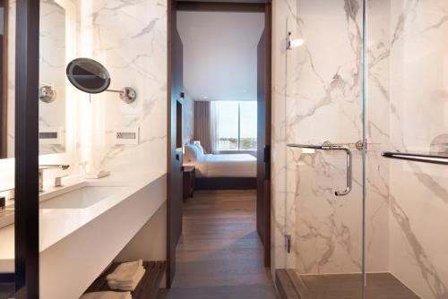 a bathroom with a walk in shower and a glass door at The Hotel & Athletic Club at Midtown in Chicago
