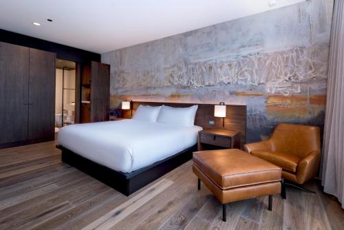 um quarto de hotel com uma cama e uma cadeira em The Hotel & Athletic Club at Midtown em Chicago