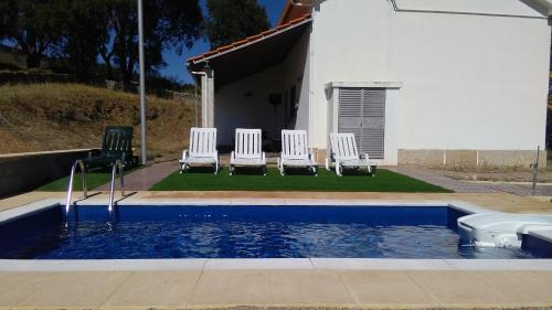 three chairs and a swimming pool in a house at Alojamento Rural de Vales in Vales