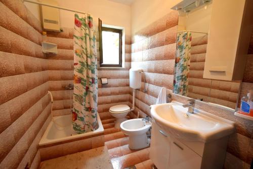 a bathroom with a sink and a toilet and a shower at Apartments Matea in Kornić