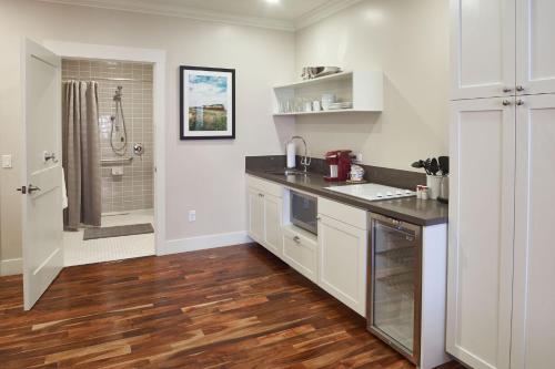 a kitchen with white cabinets and a sink and a shower at Hotel Mac in Richmond
