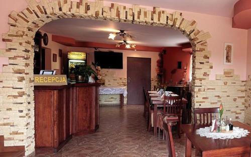 a restaurant with tables and chairs and a brick wall at Hotel Miły in Krosno