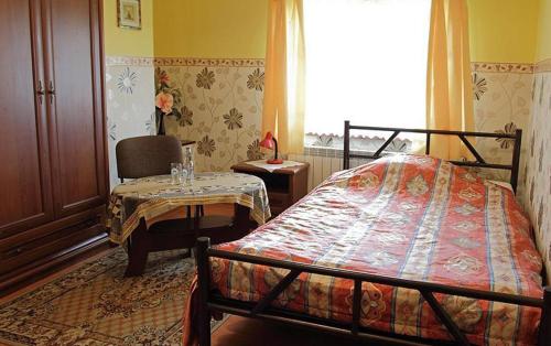 - une chambre avec un lit, une table et une fenêtre dans l'établissement Hotel Miły, à Krosno