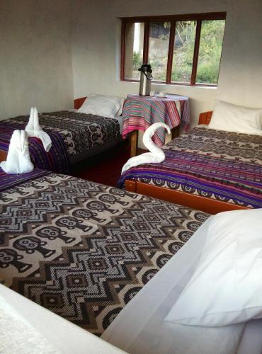 a hotel room with three beds and windows at Llactapata Lodge overlooking Machu Picchu - camping - restaurant in Salcantay