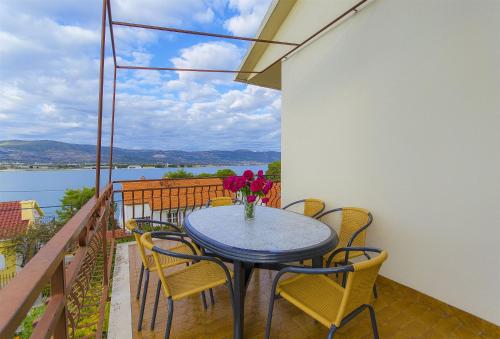 a table with chairs and a vase of flowers on a balcony at House Marija in Trogir